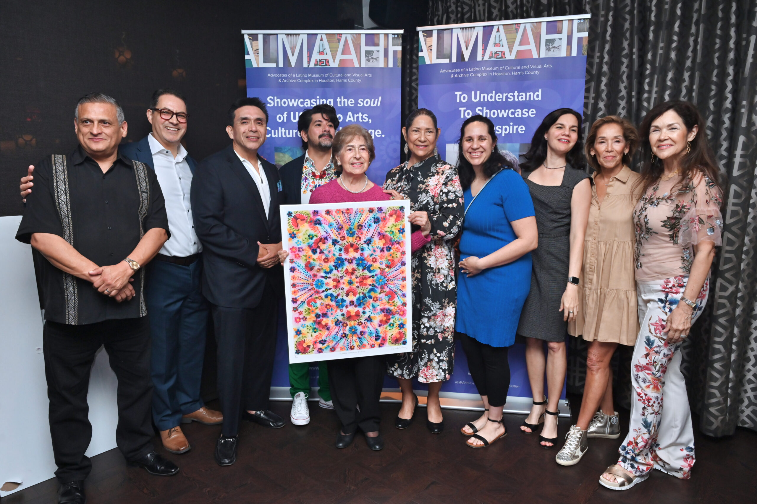 ALMAAHH supporters with colorful artwork at Madrinas y Padrinos campaign event
